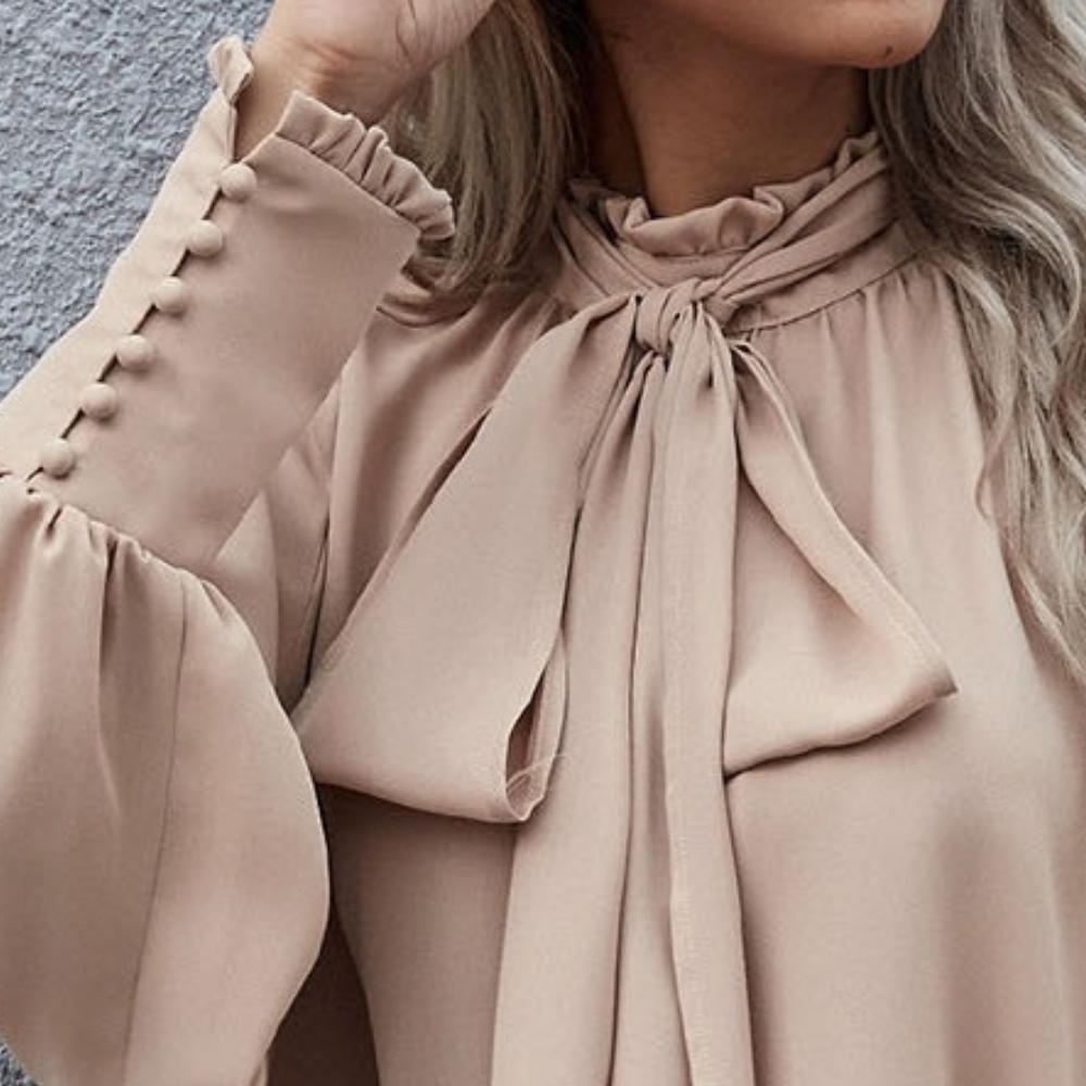 Beige Bluse mit Schleife, lange Ärmel, Knopfdetails, elegantes Damenmode-Design.
