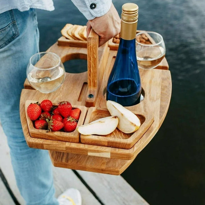 Person carrying the wooden wine table by its handle, with strawberries, pear slices, wine bottle and two glasses 5