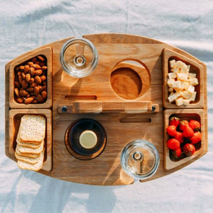 Top-down view of the wooden table with bowls of almonds, crackers, cheese and strawberries, plus a bottle and two glasses 6