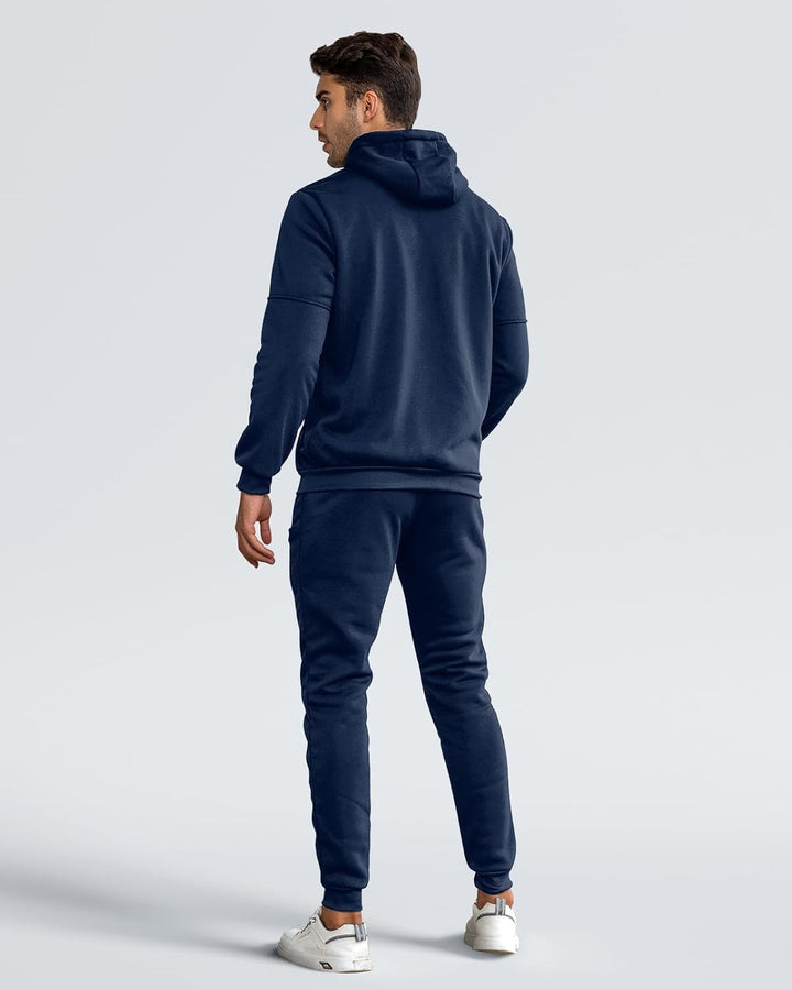 Back view of a man in a navy hooded sweatshirt and cuffed joggers, looking over his shoulder 3