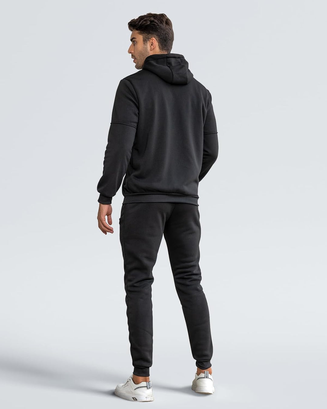 Back view of a man wearing the black hoodie and cuffed joggers, looking over his shoulder 9