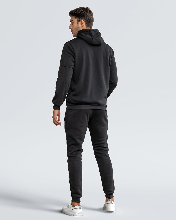 Back view of a man wearing the black hoodie and cuffed joggers, looking over his shoulder 9