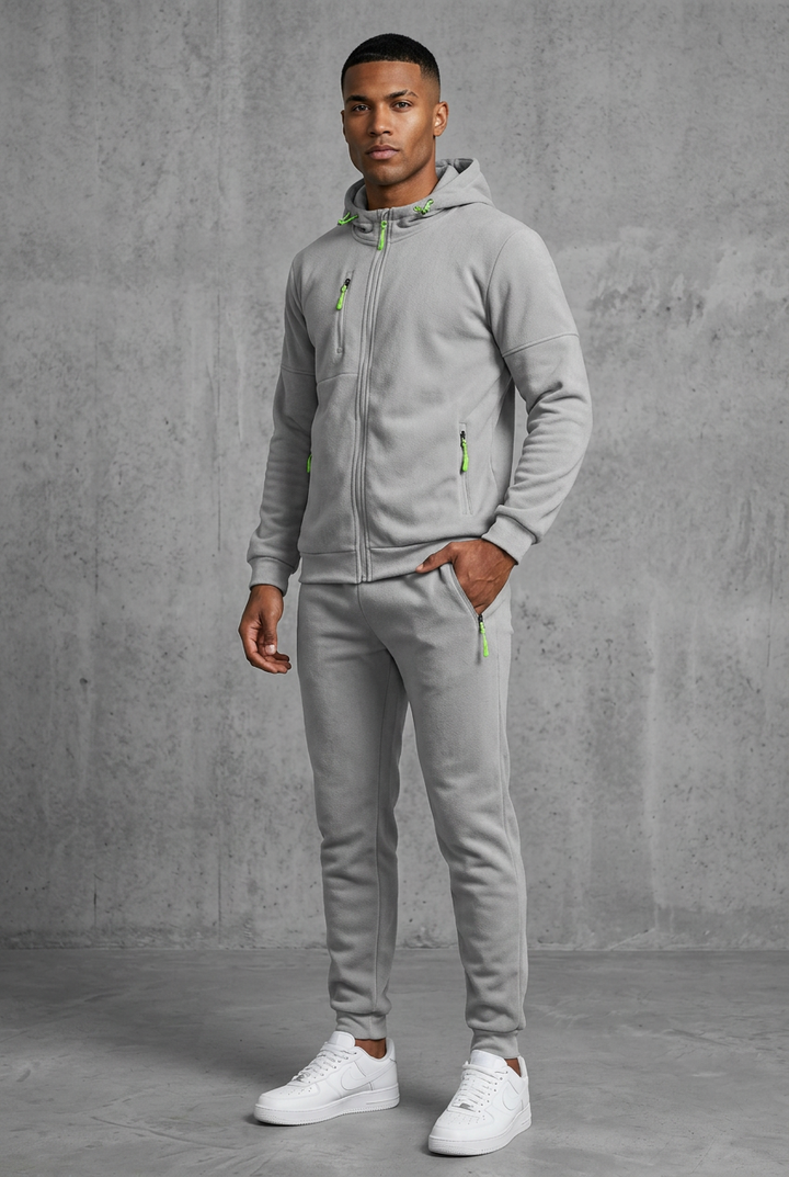 Man in light gray fleece hooded zip jacket and joggers with lime green zipper pulls, front view 10