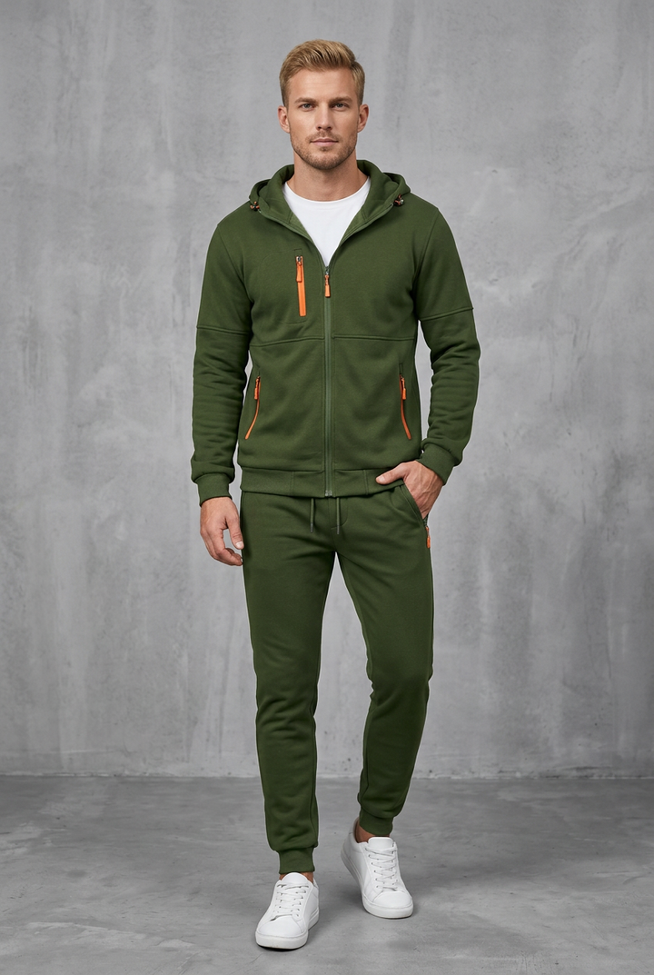 Front view of an olive green zip hoodie and joggers with bright orange zippers on a model 6