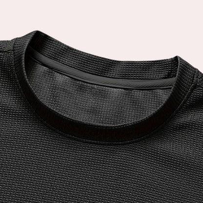 Schwarzes Sport-T-Shirt aus atmungsaktivem Mesh-Stoff, Nahaufnahme des Kragens.