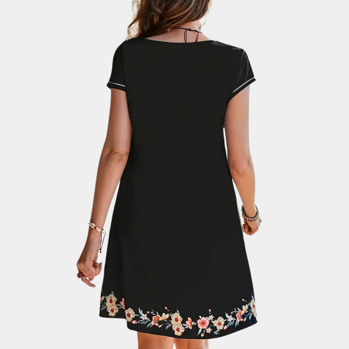 Schwarzes Damenkleid mit Blumenmuster, kurzärmelig, Sommermode, Rückansicht.