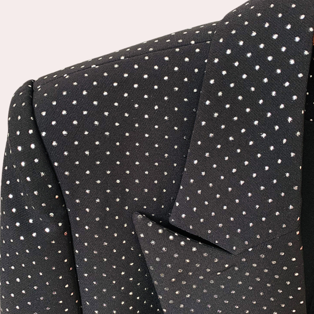 Schwarzer Blazer mit weißen Punkten, elegantes Design, Damenmode, formelle Kleidung.