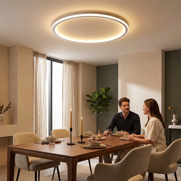 Round white ring light glowing above a wooden dining table where a man and woman sit 1