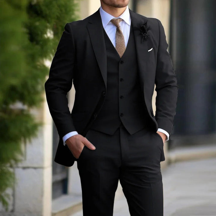 Same three-piece suit in black, worn with a white shirt and brown tie outdoors 4
