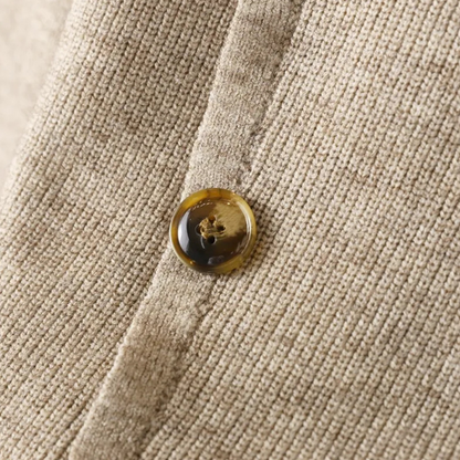 Beiger Strickstoff mit braunem Knopf, Nahaufnahme, Textur, Mode, Detailansicht.