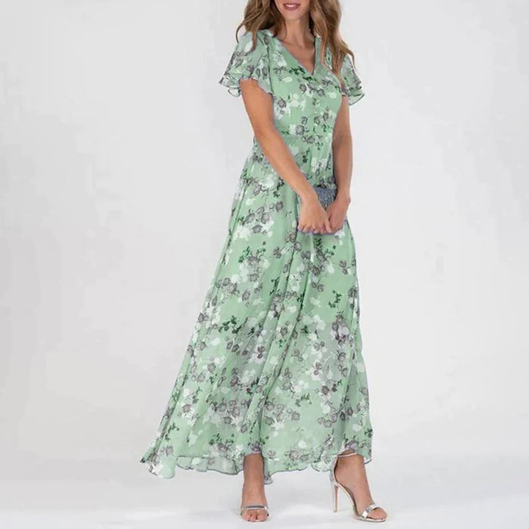 Frau in grüner, geblümter Maxikleid, V-Ausschnitt, kurze Ärmel, elegantes Sommeroutfit.