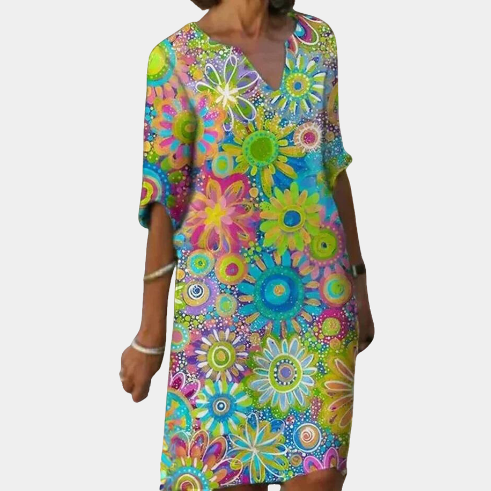 Frau in buntem, geblümtem Sommerkleid, V-Ausschnitt, knielang, lässig, modisch.