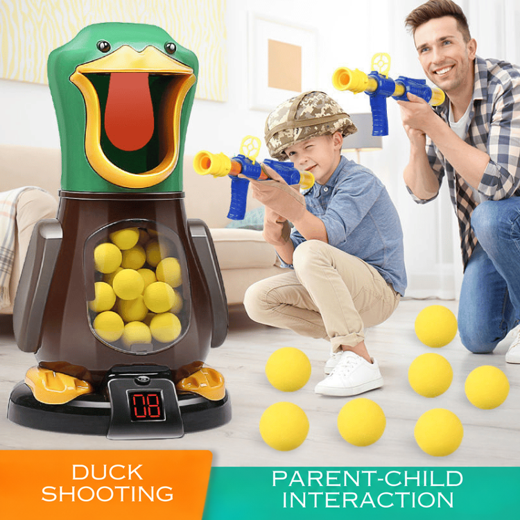 Father and son crouch in a living room aiming blasters at the duck target, foam balls scattered 2