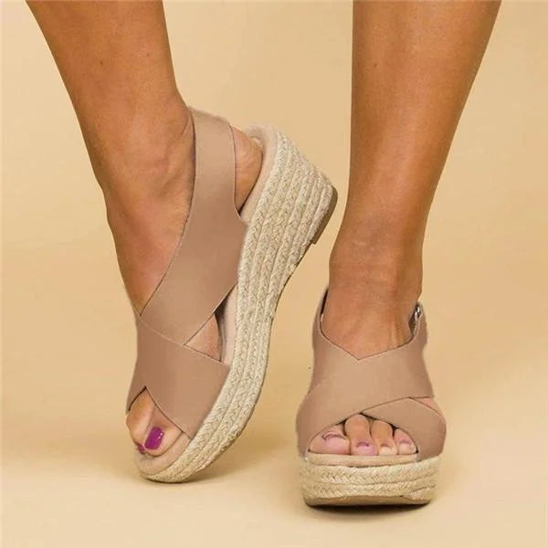 Tan crisscross sandals worn with feet angled, showing the open toe, braided wedge and slingback strap 3
