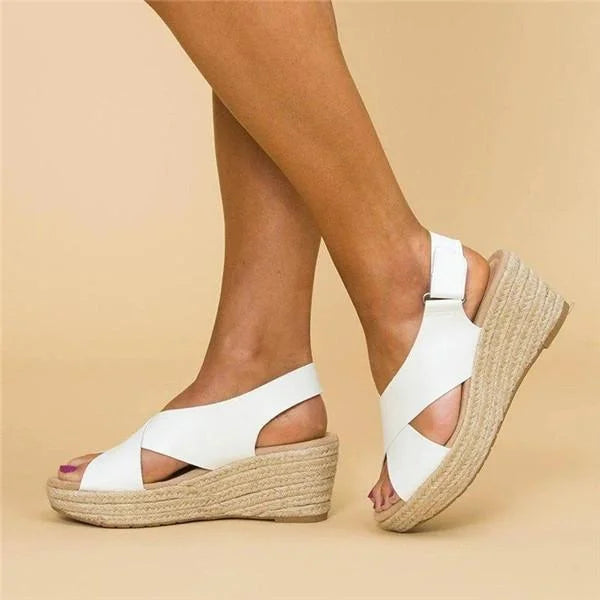 White crisscross-strap wedge sandals worn in side view, showing the adjustable heel strap and braided platform 5