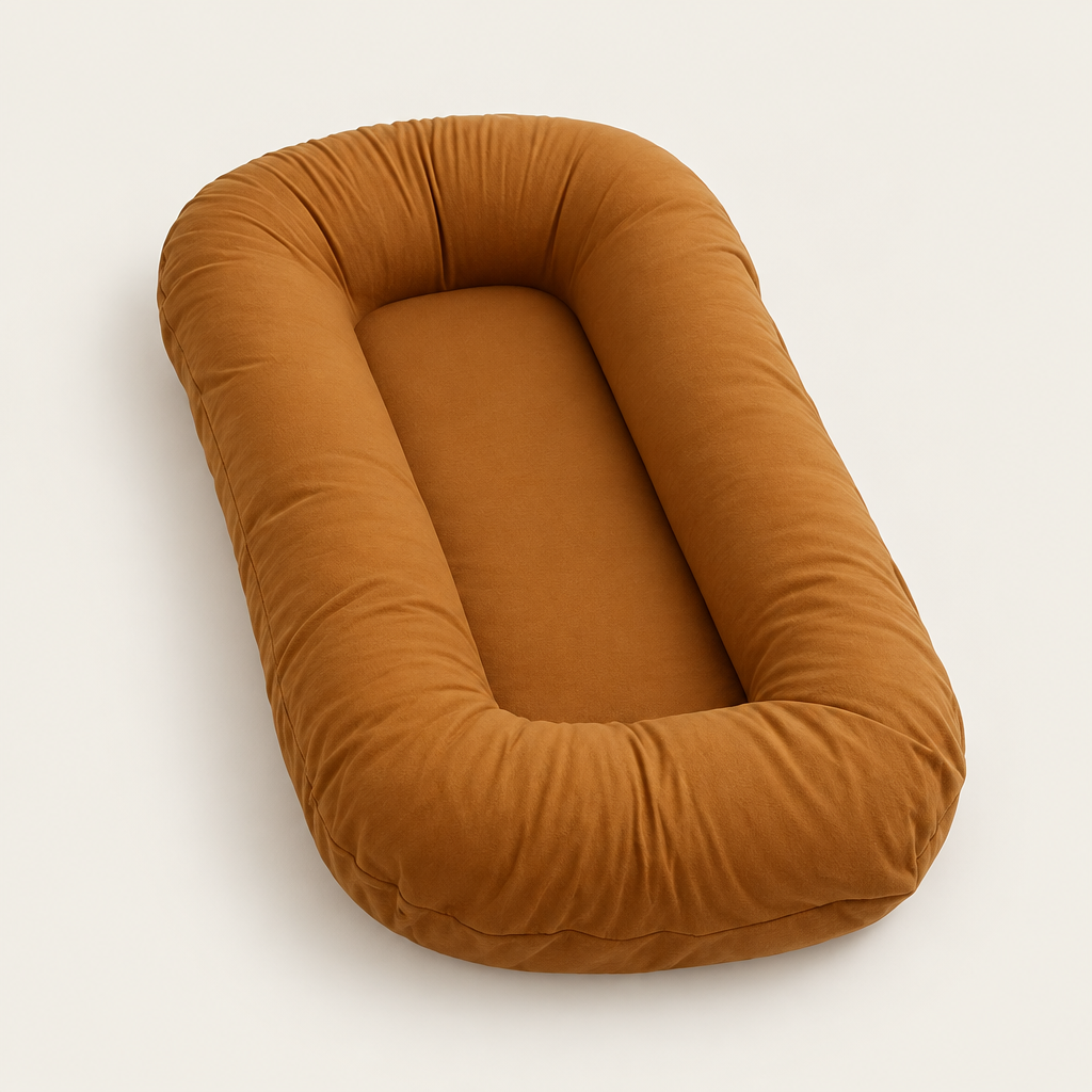 Empty caramel brown oval pillow with raised rim and flat center, shown from an angle 9