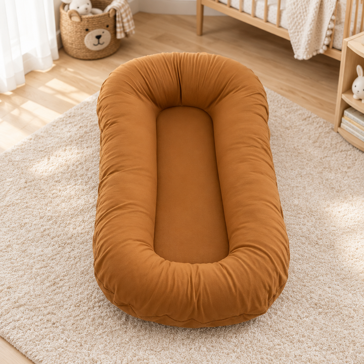 Empty caramel-brown cushion with a raised rim, on a cream rug in a nursery 9