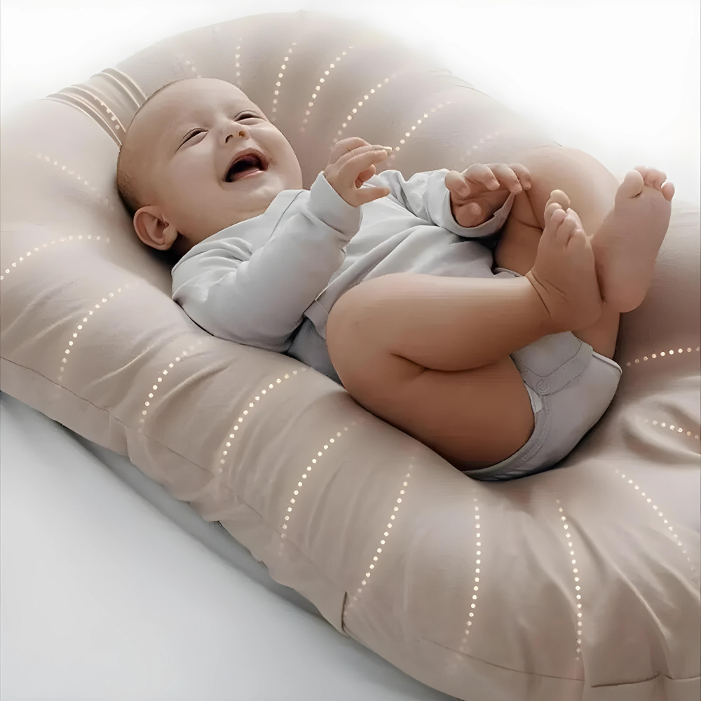 Close-up of a laughing baby lying on a soft beige lounger with dotted stitched lines 1