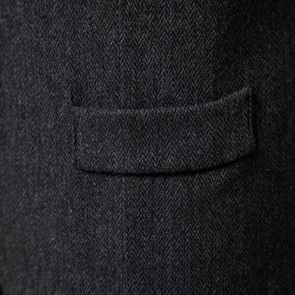 Dunkelgrauer Wollstoff mit Fischgrätmuster, Detailansicht einer Anzugtasche.