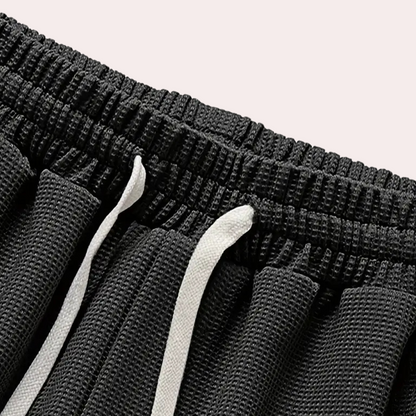 Schwarze Sportshorts mit elastischem Bund und weißen Kordeln, atmungsaktives Material.
