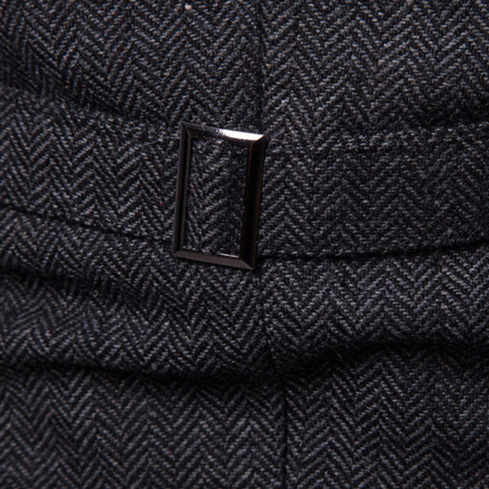 Dunkelgrauer Tweed-Stoff mit Fischgrätmuster und rechteckiger Metallschnalle.