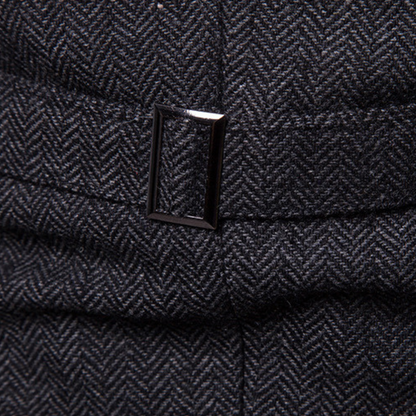 Dunkelgrauer Tweed-Stoff mit Fischgrätmuster und rechteckiger Metallschnalle.