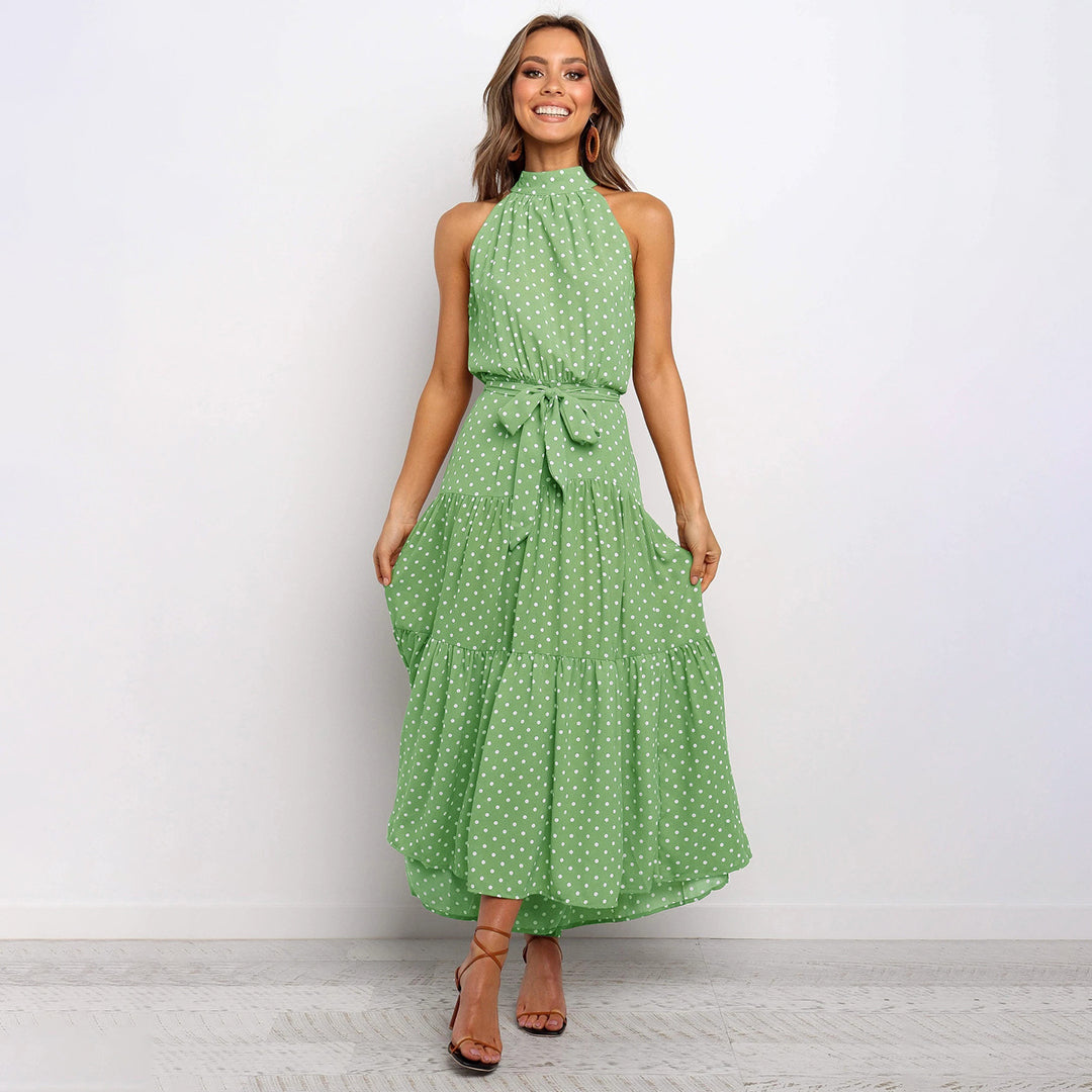 Frau in grüner gepunkteter Maxikleid, ärmellos, mit Schleife, elegantes Sommeroutfit.
