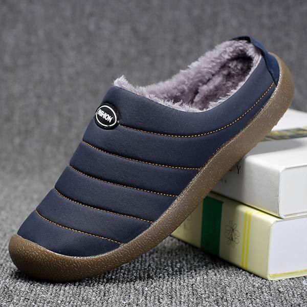 Navy blue quilted slipper tilted on books, showing the side profile and fleece interior 7