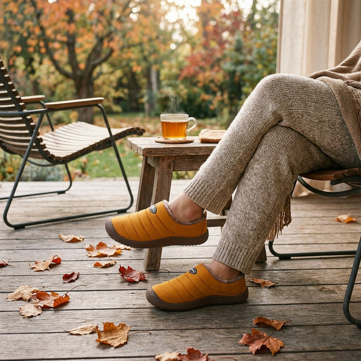 Mustard quilted slippers worn on a wooden deck beside a cup of tea and autumn leaves 1
