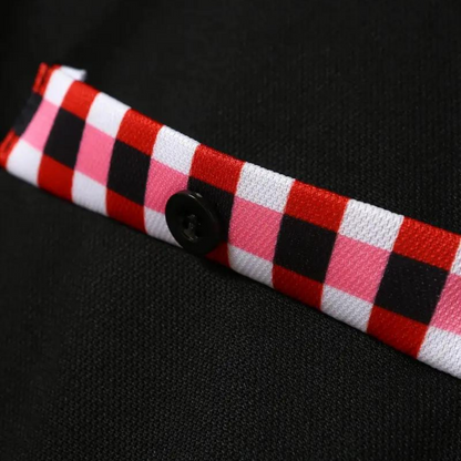 Schwarzer Stoff mit rot-weiß-schwarzem Karomuster und Knopf, Textil, Modeaccessoire.