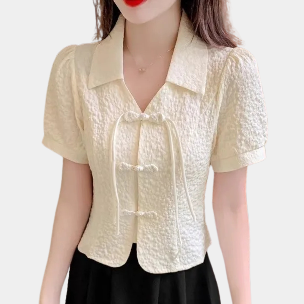 Damenbluse cremefarben, kurzärmelig, strukturierter Stoff, elegantes Design, V-Ausschnitt.