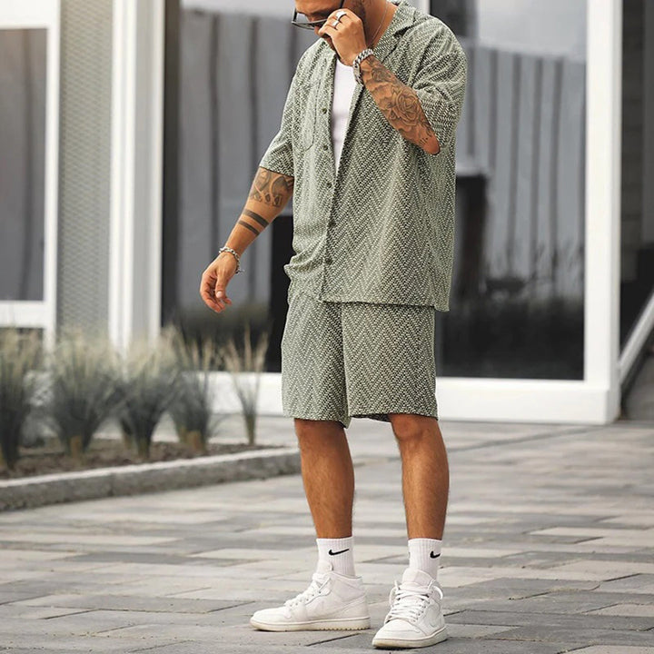 Mann in grünem Sommer-Set, Hemd und Shorts, modisch, lässig, draußen, stilvoll gekleidet.