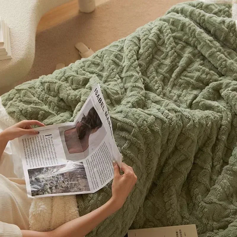 Person liest Zeitschrift auf grüner, gestrickter Decke im Wohnzimmer, gemütliche Wohnkultur.