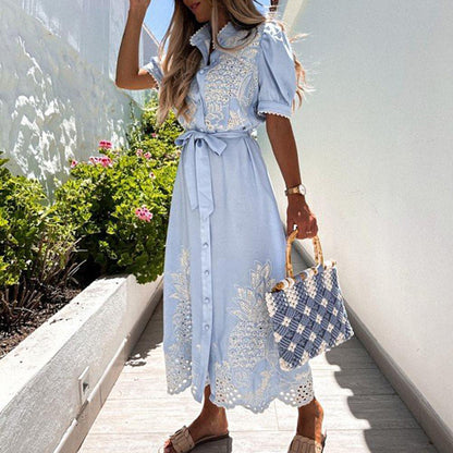 Frau in hellblauem Maxikleid mit Spitze, Sommermode, Garten, Strohtasche, Blumen, elegant.