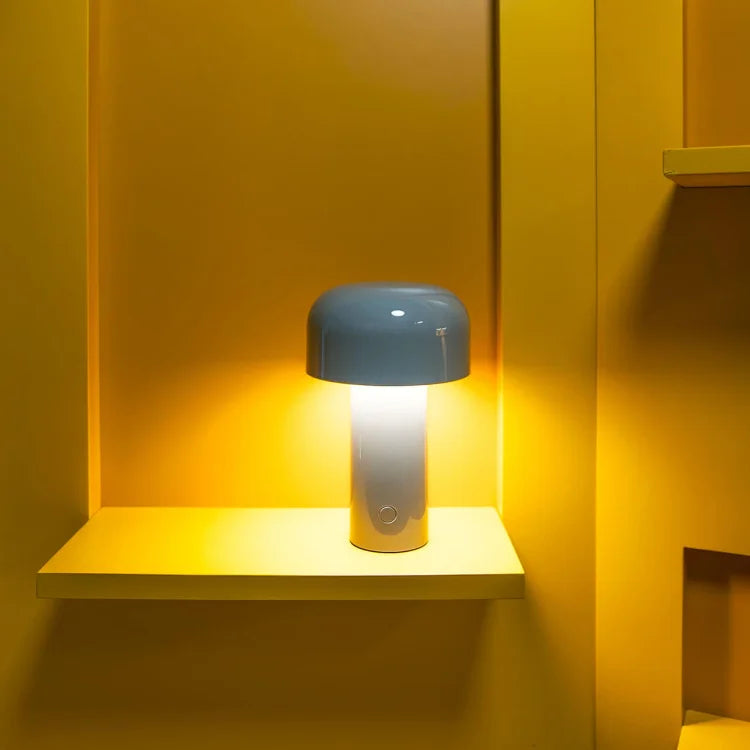 Lit lamp with a blue-gray dome on a yellow wall shelf, casting golden light 12