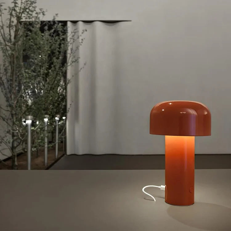 Glossy red-orange mushroom lamp lit on a surface with a white charging cable attached 25