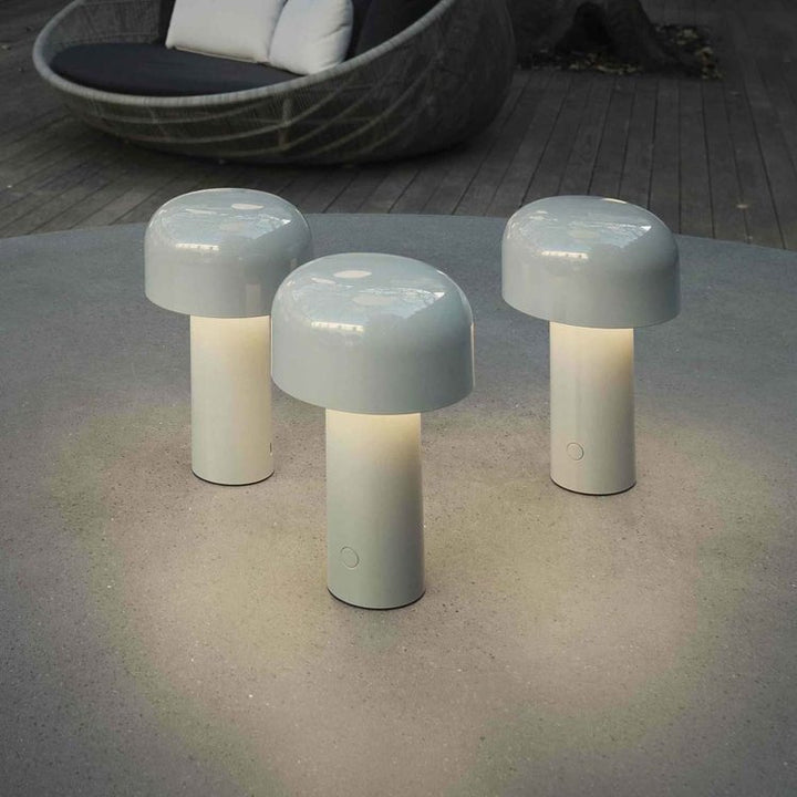 Three light gray mushroom lamps glowing on an outdoor round table, with a wicker lounge chair behind 6