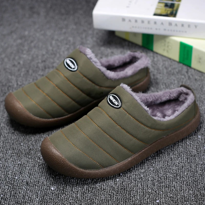 Pair of olive green quilted fleece-lined slippers on gray carpet, with books behind 2