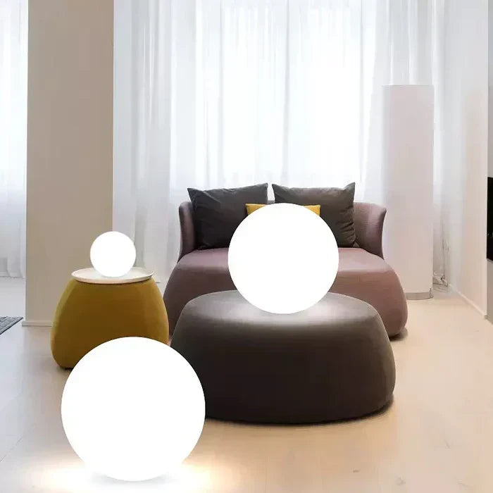 Three white glowing spheres used indoors in a living room with a sofa and ottoman 14
