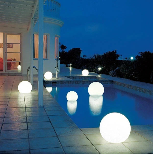 White spheres glowing around a backyard pool and patio of a house at dusk 18