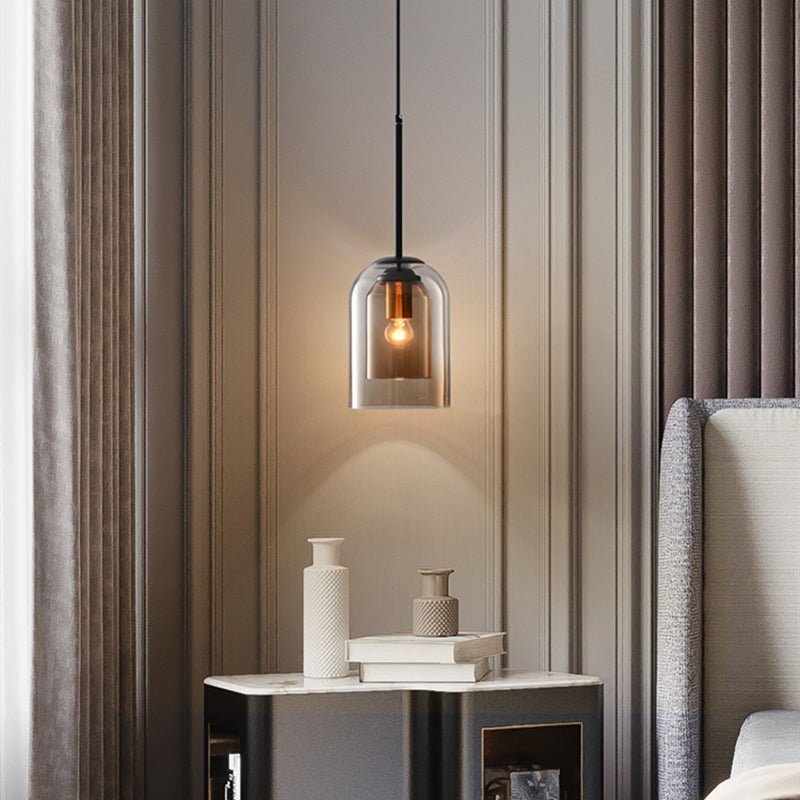Single amber pendant glowing beside a bed, above a marble-topped nightstand with vases and books 3