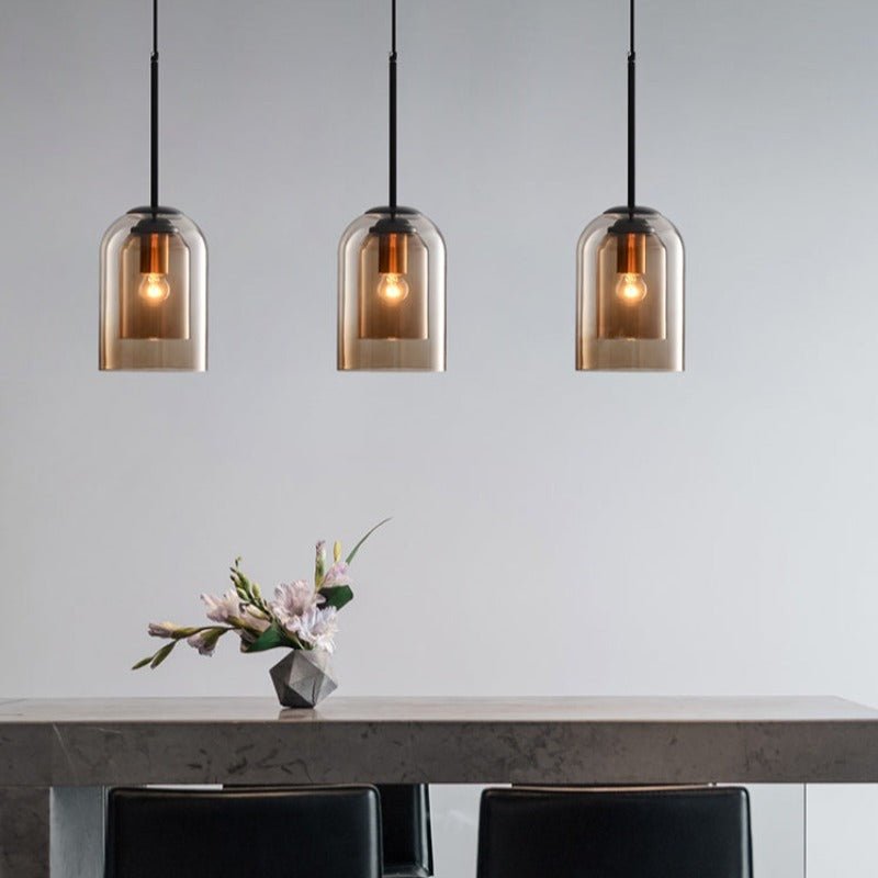Three amber pendants in a row above a stone dining table with a flower vase 6