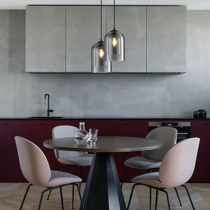 Two smoke gray pendants at different heights over a round dining table in a modern kitchen 7