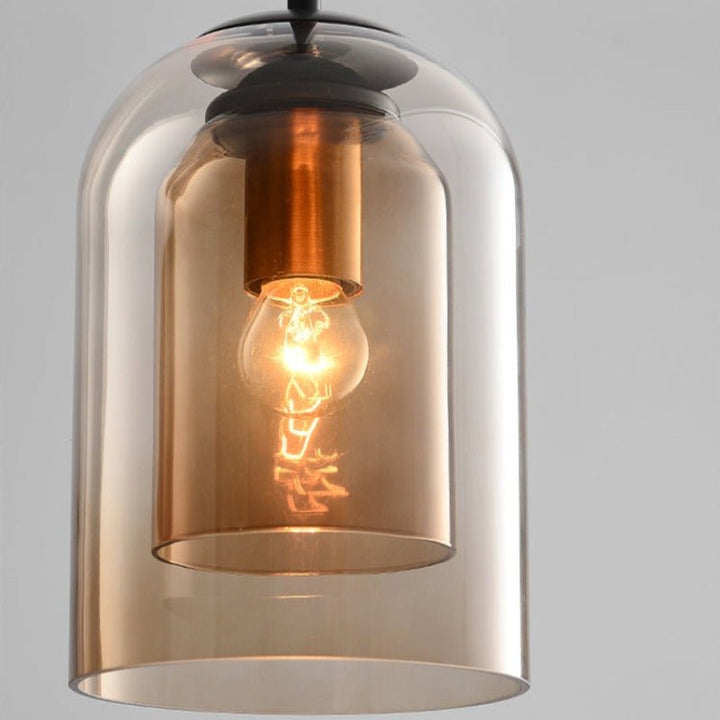 Close-up of the amber double glass shades with the lit bulb and copper-toned socket inside 9