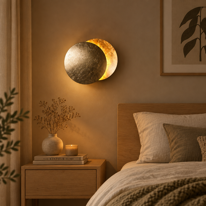 Textured silver-toned lamp glowing warmly above a wooden nightstand with a vase and candle in a cozy bedroom 1