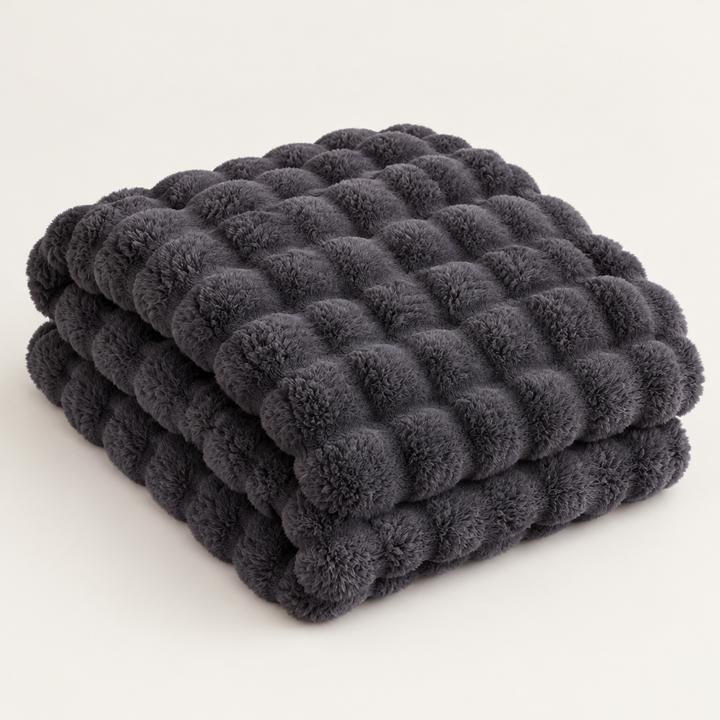 Dark gray plush blanket folded in a stack on a plain background, showing its thick raised bubble texture 14