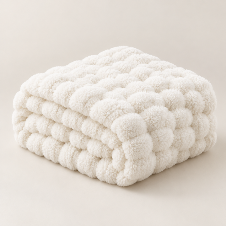 Cream-white plush blanket folded into a stack on a plain background, showing its fluffy bubble texture 16