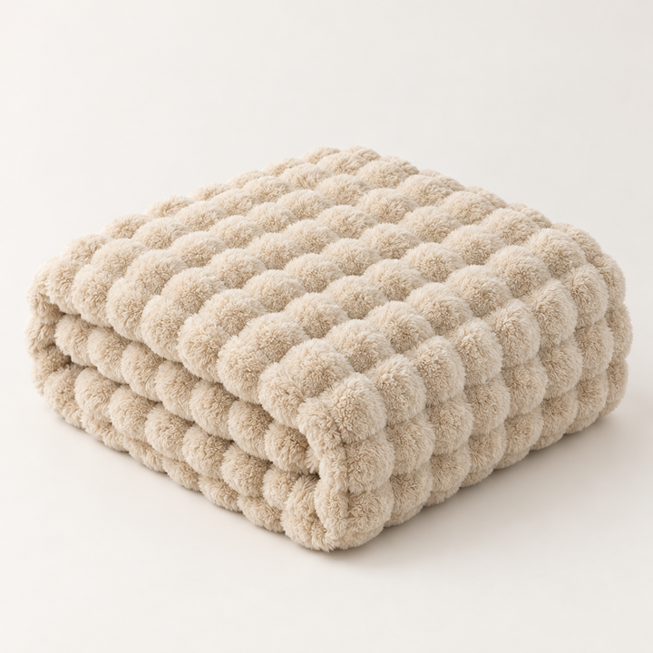 Beige plush blanket folded in a stack on a plain background, showing its pom-pom-like bubble texture 13