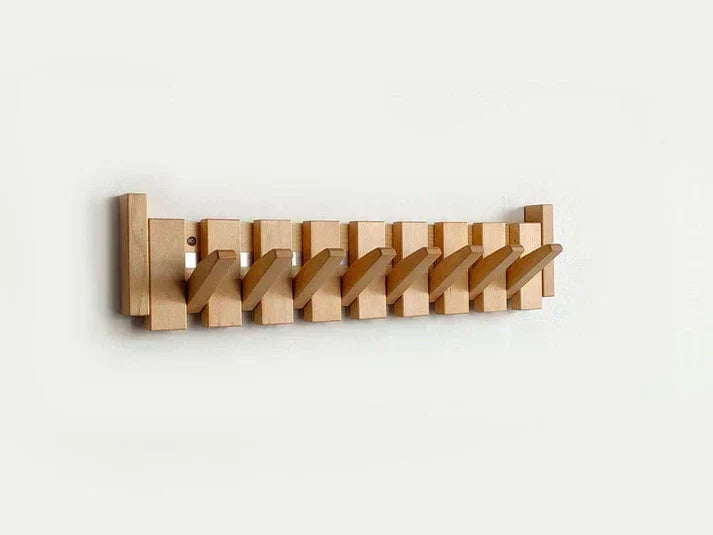 Light natural wood rack with all hooks folded out diagonally, shown on a plain white wall 8