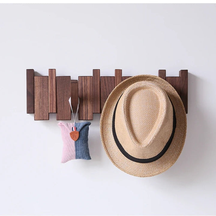 Dark walnut rack with a straw fedora and a small pink and denim pouch hanging from it 4